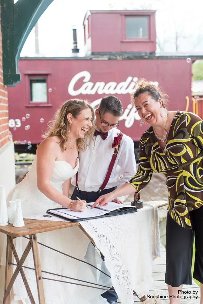Bride and Groom laughing with officiant
